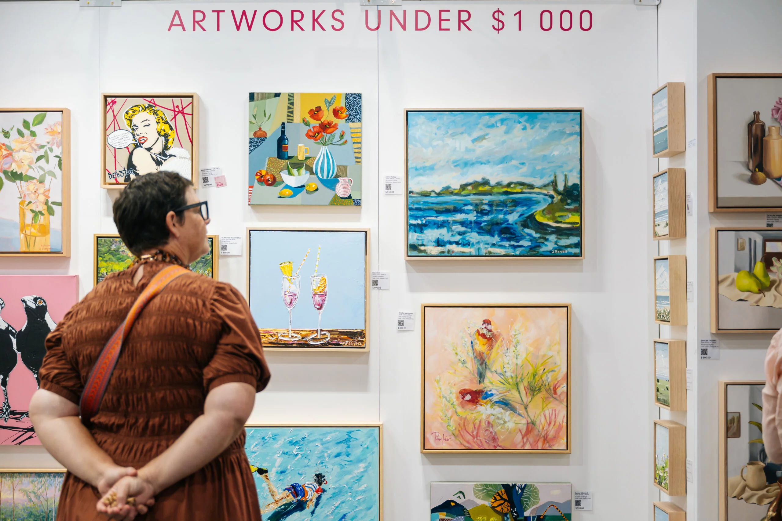 Woman looking at artwork under $1000 wall